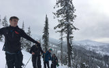 backcountry skiers pause while skinning