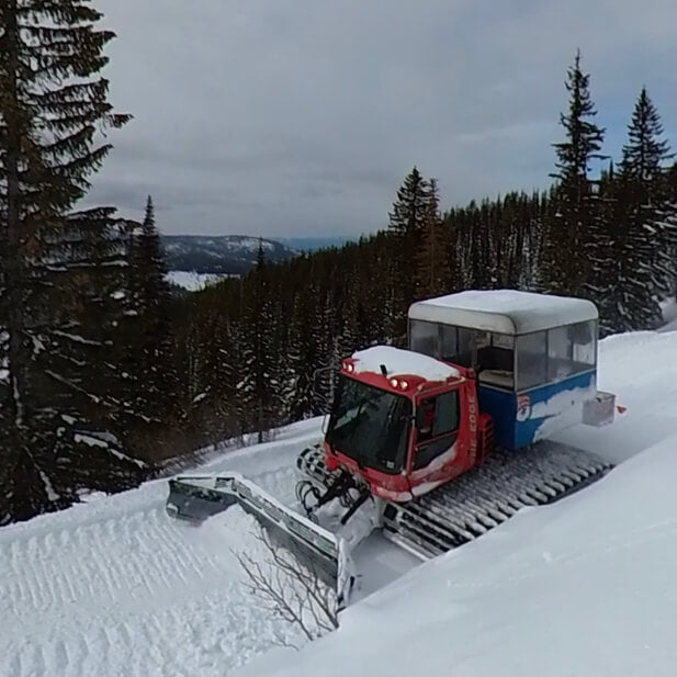 A snowcat making a backcountry cat-road